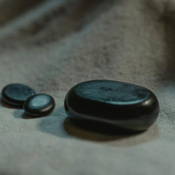 A serene composition of balanced stones and a soft leaf, symbolizing well-being.
